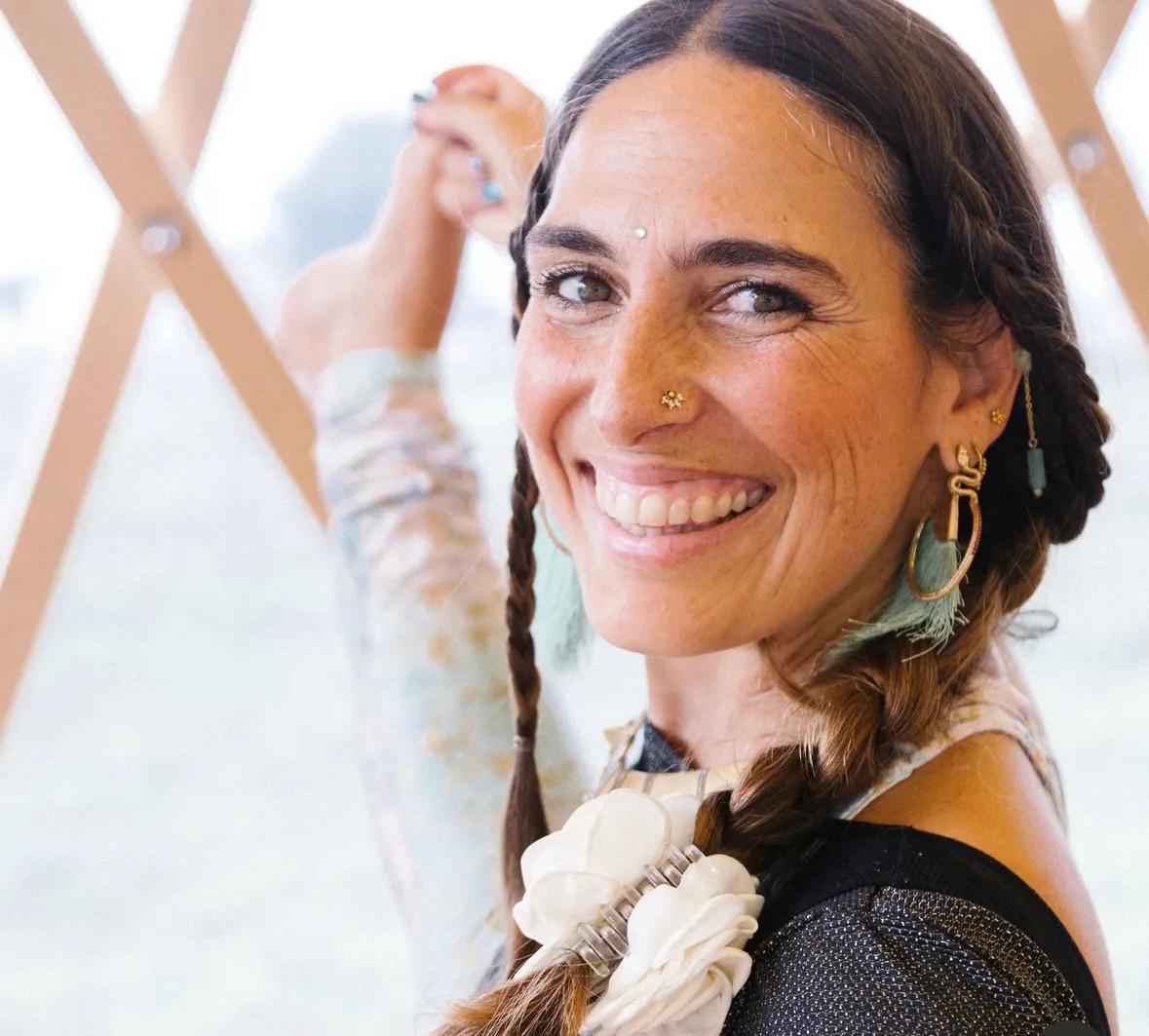 Isa Guitana smiling, mid-pose, during an Ashtanga Yoga session