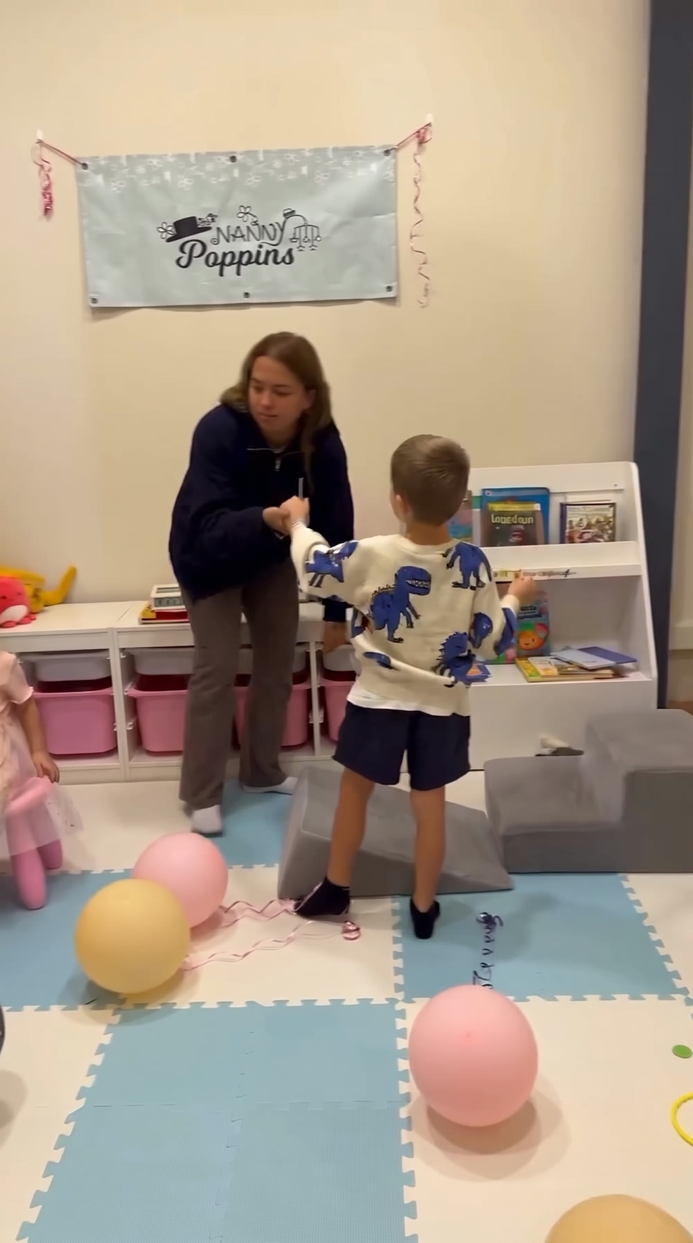 Uma ama com uma criança no Clube Infantil